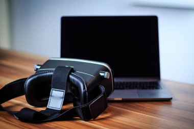 VR gözlük ve dijital öğrenme simgeleyen bir tablo üstünde laptop