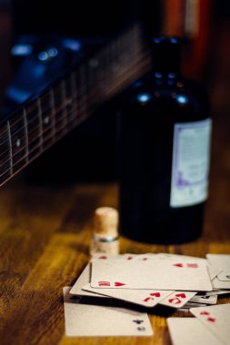 Likör şişesi, iskambil ve gitar 