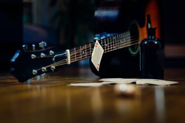 Likör şişesi, iskambil ve gitar 