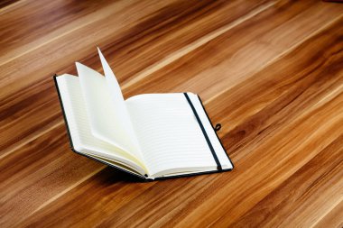 Tahta bir masanın üzerinde açık bir defter