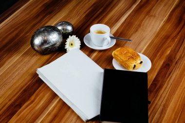 Boş gazete, defter, espresso ve kruvasan