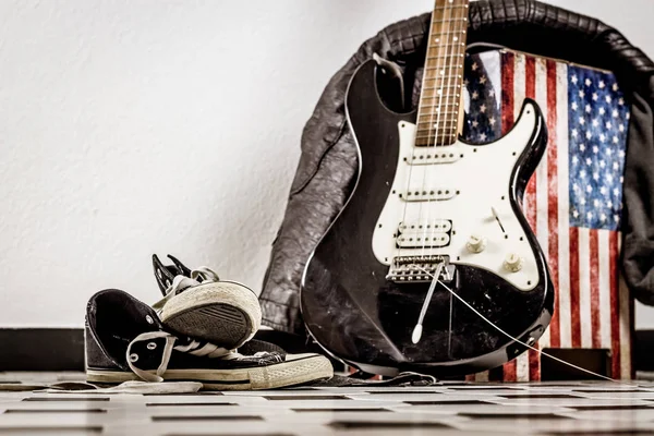 Elektro gitar, deri ceket ve spor ayakkabı 