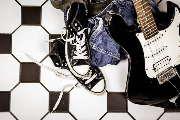 Elektro gitar, deri ceket ve spor ayakkabı