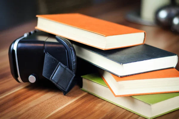 VR glasses and books on a table symbolizing digital learning