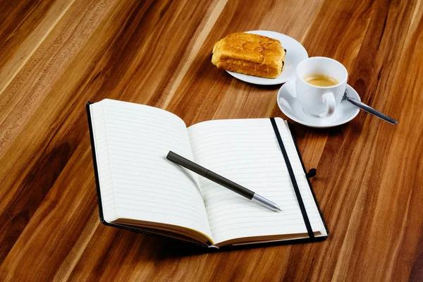 Notebook, pen, espresso en croissantje — Stockfoto