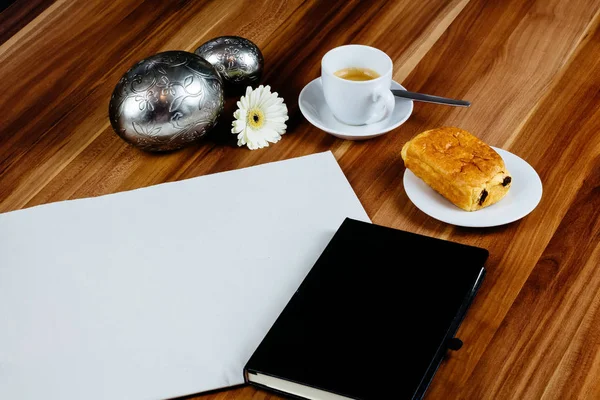 Blank newspaper, notebook, espresso and croissant