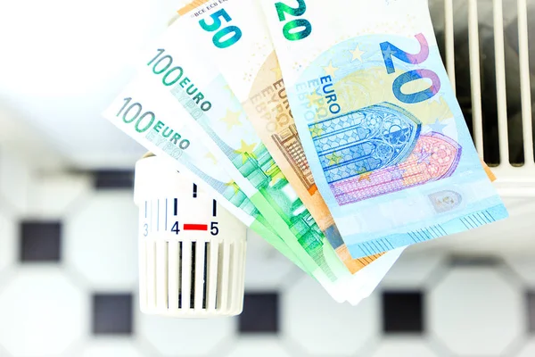 Деньги на радиаторе символизируют дорогостоящие расходы на отопление — стоковое фото