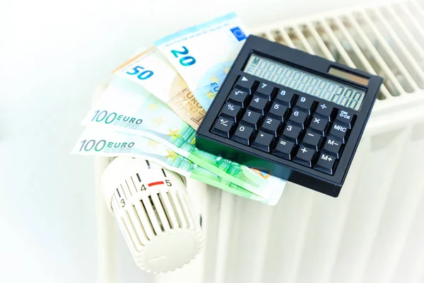 Para ve hesap makinesi bir radyatör üzerinde sembolize pahalı ısı