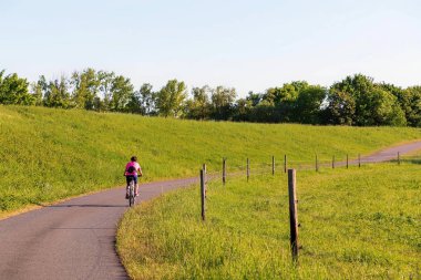 Bir bisikletçi lezbiyen güneş ışığında sürmek.