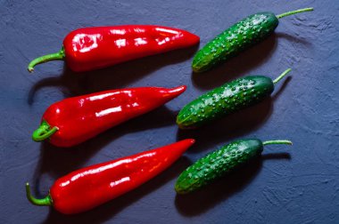 Kırmızı biber, taze salatalık bir mavi yüzey, metin, üstten görünüm, sağlıklı bir diyet kavramı için yer, 