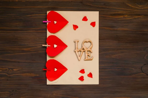 Enveloppe avec des cœurs rouges sur un fond en bois, le concept de Saint-Valentin, vue de dessus — Photo