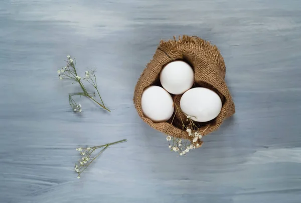 Dekor için Paskalya tatili, yumurta bir ahşap açık renkli, üstten görünüm, metin için boş alan çuval bezi doku — Stok fotoğraf