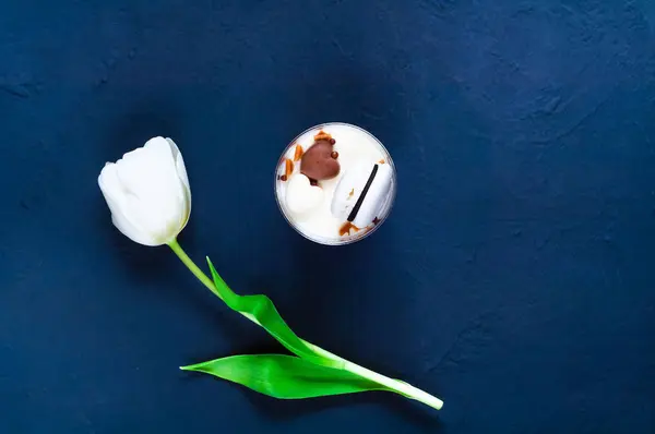 Corações de chocolate e uma tulipa branca em um fundo escuro, um conceito de decoração festiva, espaço para texto — Fotografia de Stock