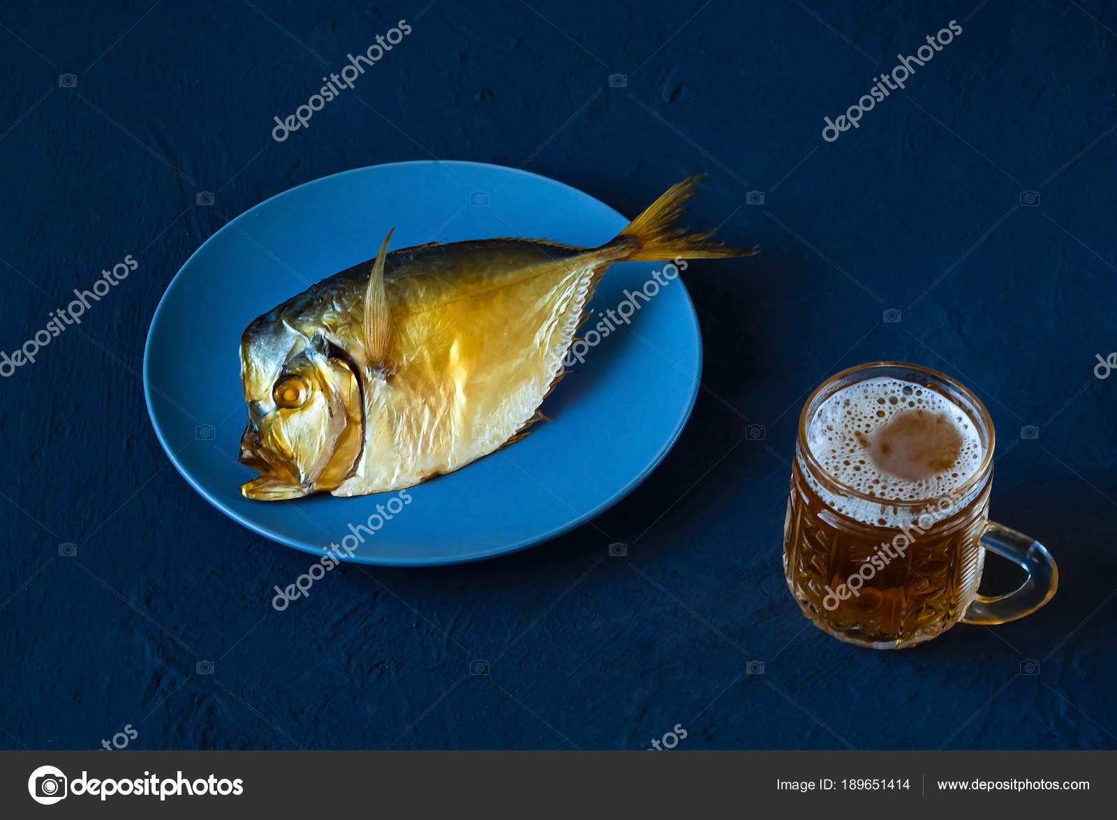 Pesce Affumicato Su Un Piatto Blu E Birra In Un Calice Di Vetro Su