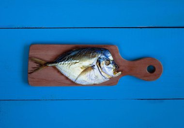 mavi bir arka plan üzerinde bir ışık ahşap tahta üzerinde balık füme