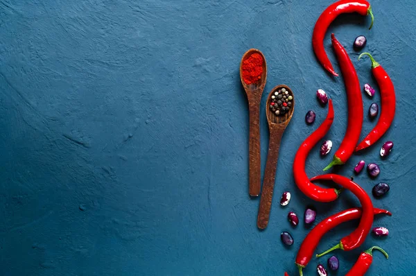 辣椒, 在蓝色混凝土背景下的香料和豆类木匙. — 图库照片