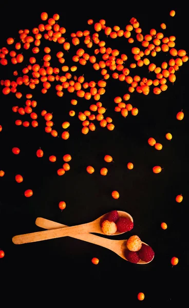 Orangefarbener Sanddornhintergrund, isoliert auf schwarzem Hintergrund, herunterfallend. — Stockfoto