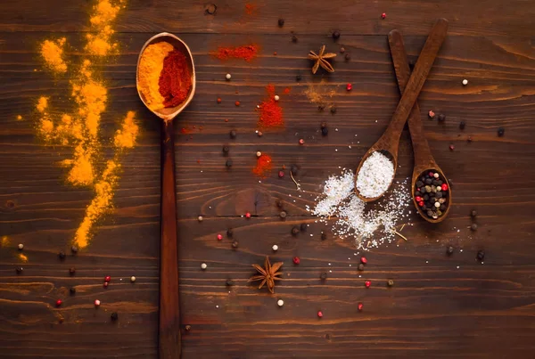 Colores tradicionales indios Holi en polvo, especias, cucharas de metal e ingredientes sobre un fondo de madera. Fondo con especias . — Foto de Stock