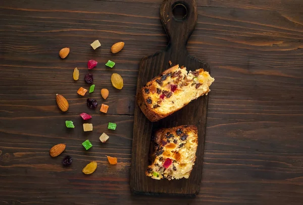 Bitar av hembakade muffins med russin, kanderad frukt och mandel på en trä bakgrund. Hälsosam frukostingredienser — Stockfoto