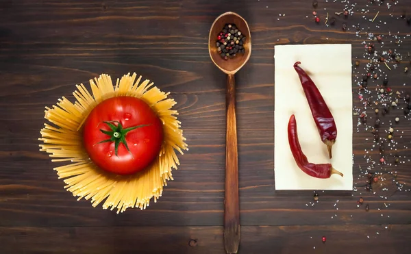 tahta kaşıkla baharat ve taze kırmızı domates, bir ahşap arka plan, üstten görünüm, kopya alanı, spagetti çevrili minimalizm