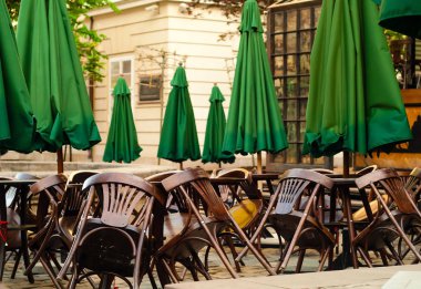 ahşap masa ve sandalyeler şehir arka planda, yaz Cafe konsepti ile yeşil şemsiye açık havada, alanı Kopyala