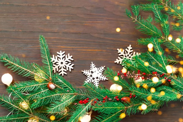 Χριστουγεννιάτικη γιρλάντα από κλαδιά ελάτης σε ξύλινο φόντο. Πρωτοχρονιάτικες διακοπές. Θολή επίδραση. Πάνω όψη, αντιγραφή χώρου — Φωτογραφία Αρχείου