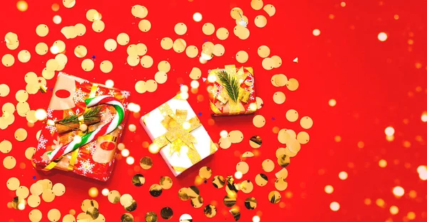 Presentes de Natal em fundo vermelho com brilhos. Close-up, espaço de cópia — Fotografia de Stock