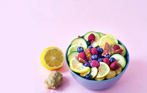 Fruktsallad av vilda bär och exotiska frukter på rosa bakgrund. Begreppet hälsosam kost, noll avfall. Närbild — Stockfoto