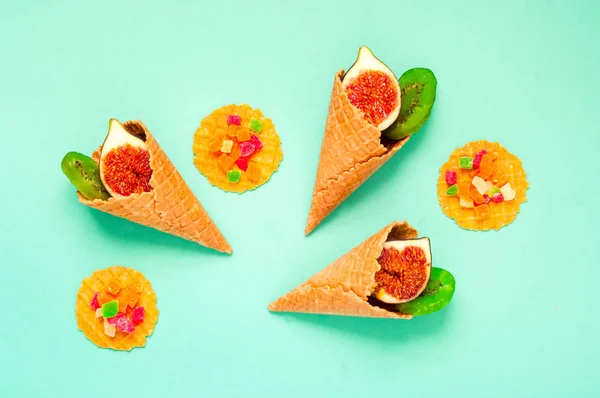 Waffle cones with organic fruits and sweets on mint color background. Sweetest Day. Close-up — Stockfoto