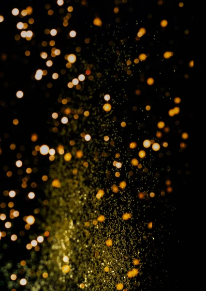 Fond noir avec des étincelles dorées. Effet flou. Concept de composition festive.Gros plan, vertical — Photo