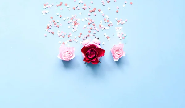 Mavi arka planda çalar saat ve gül çiçekli şenlikli bir konsept. Sevgililer Günü. Moda rengi 2020. Yakın plan. — Stok fotoğraf
