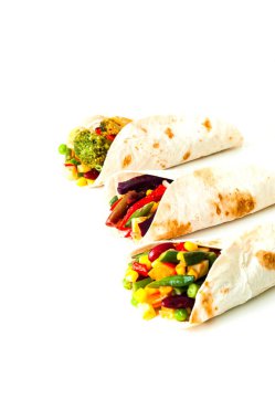 Meksika usulü sebzeli tortilla ve beyaz arka planda mantar dolgusu. Sağlıklı beslenme konsepti. Bütçe dostu menüler. Yakın plan, dikey.