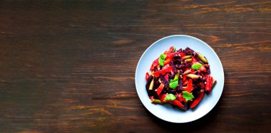 Ahşap arka planda mavi tabakta pişirilmiş sebzeler. Asya yemekleri konsepti. Bütçe dostu menüler. Yakın plan.