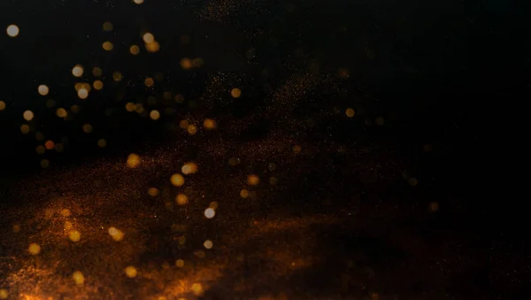 Black background with golden sparkles. Blurred effect. Concept for festive background or for project.Close-up
