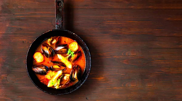 Omułki w czerwonym sosie curry na drewnianym tle. Koncepcja zdrowego i satysfakcjonującego posiłku przekąskę — Zdjęcie stockowe