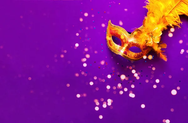 Maska karnawałowa na fioletowym tle z iskrami. Świąteczne tło dla projektów.Close-up — Zdjęcie stockowe