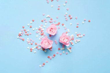 Sevgililer Günü. Mavi arka planda gül çiçekli tatlı konfetiden oluşan kalp şekli. Tebrik kartı ya da metin tasarımının şablonu
