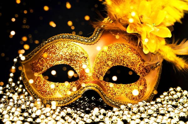 Zlatý karneval maska na černém pozadí se stříbrnými korálky. Koncept Mardi Gras. Detailní záběr — Stock fotografie