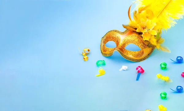 Golden Carnival mask on blue background with with colored confetti. Mardi gras festive concept. Copy space — 图库照片