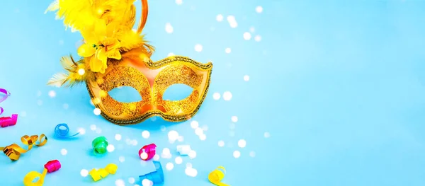 Golden Carnival mask on blue background with with colored confetti. Mardi gras festive concept. Copy space — 图库照片