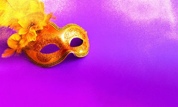 輝く紫色の背景に黄金のカーニバルマスク ぼやけた効果 マルディグラの概念 コピースペース クローズアップ — ストック写真