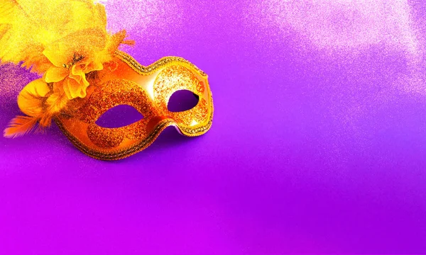 Mor arka planda parıltılı Altın Karnaval maskesi. Bulanık etki. Mardi Gras konsepti. Boşluğu kopyala, yakın plan