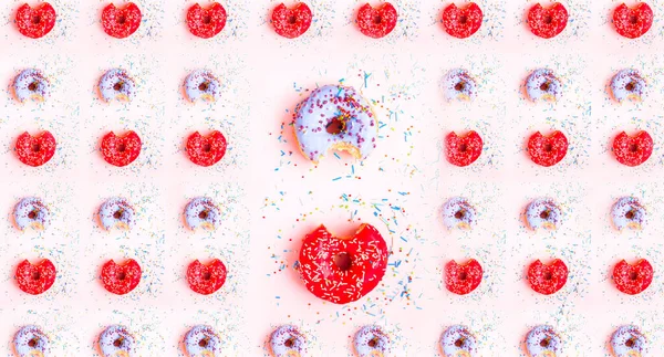 Gekleurde donuts met kleurrijke hagelslag op roze achtergrond. Nationaal Donut of Donut dag concept. Patroon — Stockfoto