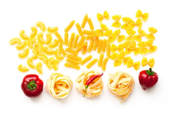 Diverse ongekookte pasta met ingrediënten geïsoleerd op witte achtergrond. Voedselconcept. Close-up — Stockfoto