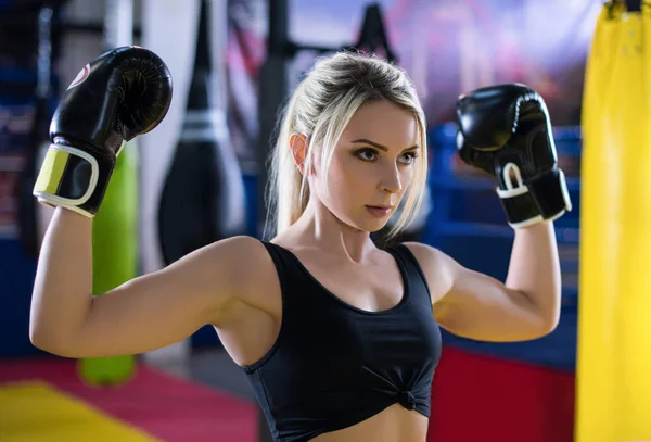 Girl with white hair in Boxing gloves shows biceps. Girl boxer a