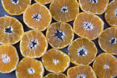 Siyah arka planda yuvarlak mandalina parçaları. mandalina dokusu