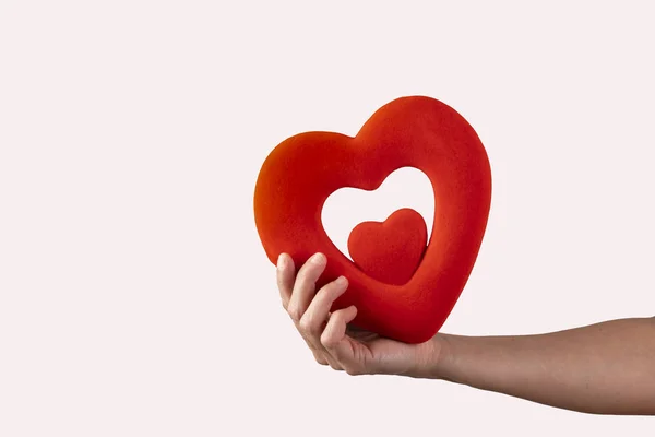 Woman holds in her hands a red heart on a white background, concept valentines day — Stock Photo, Image