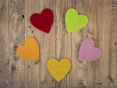 ceviz ağacından bir arka planda çember oluşturan renkli kalpler. Sevgililer Günü kavramı