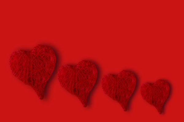 Corazones de diferentes tamaños sobre un fondo rojo. Concepto del Día de San Valentín — Foto de Stock