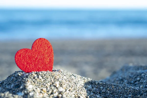 Red heart on a mountain of sand by the sea. concept of san valentine — Stock Photo, Image